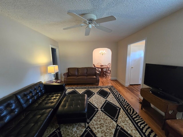 living room featuring a textured ceiling, hardwood / wood-style floors, and ceiling fan