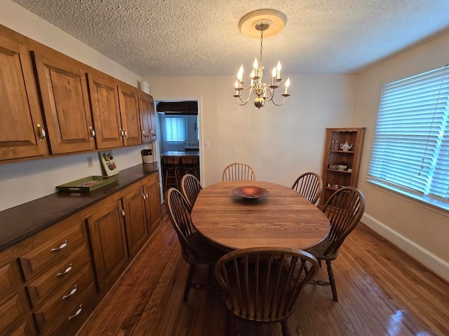 dining space with a textured ceiling, a notable chandelier, and dark hardwood / wood-style flooring