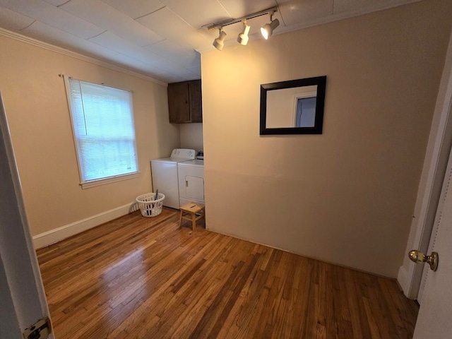 interior space featuring crown molding, dark hardwood / wood-style flooring, rail lighting, and separate washer and dryer