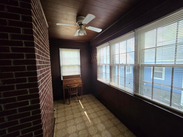 unfurnished sunroom featuring a wealth of natural light, ceiling fan, and wooden ceiling