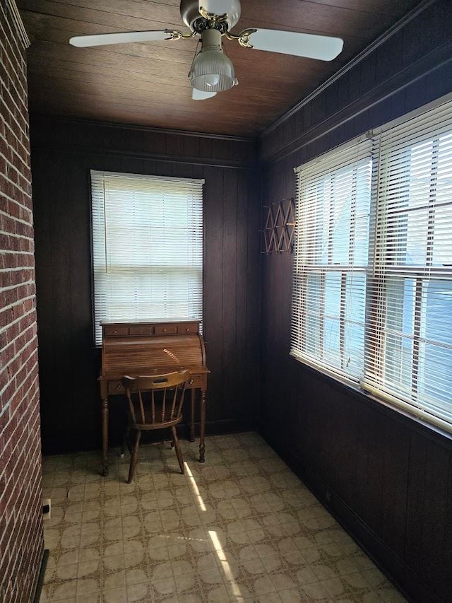 dining room featuring wood ceiling, brick wall, ceiling fan, and wooden walls