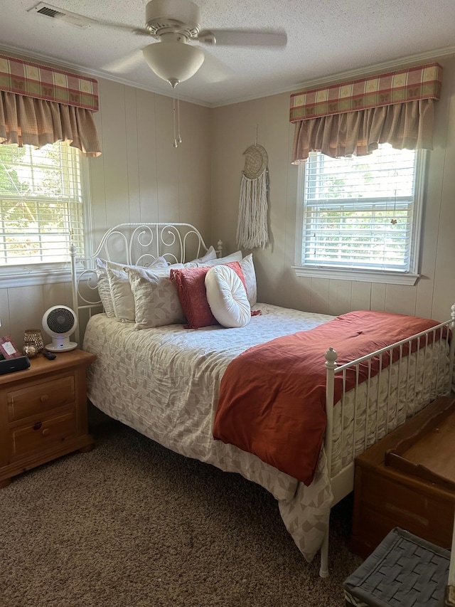 carpeted bedroom featuring a textured ceiling, crown molding, and ceiling fan