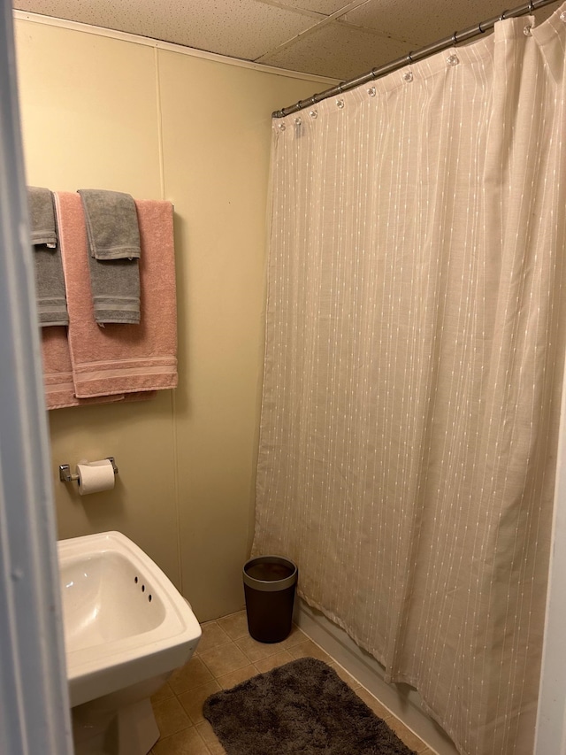 bathroom featuring a paneled ceiling, sink, tile patterned floors, and walk in shower