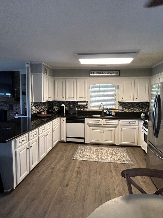 kitchen with a wealth of natural light, white appliances, dark hardwood / wood-style flooring, and decorative backsplash