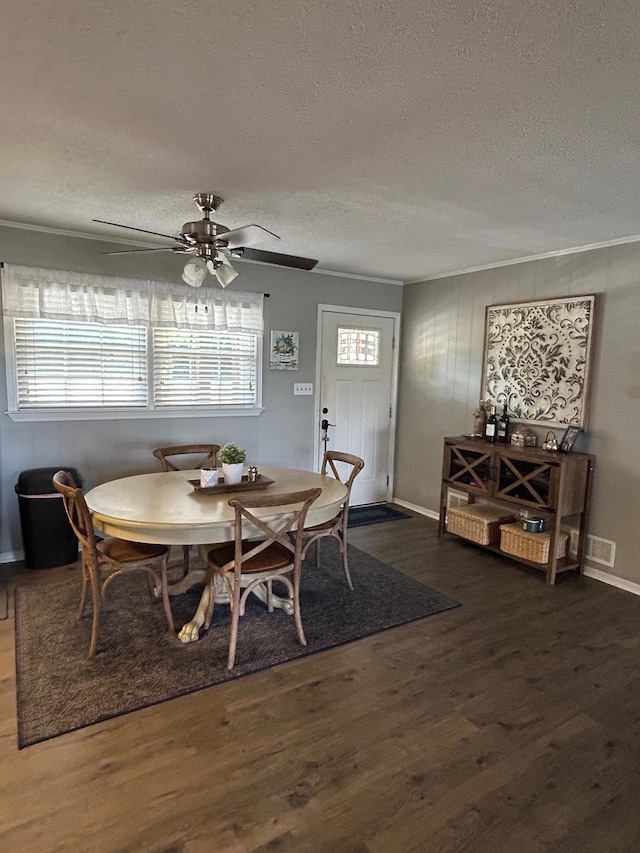 dining room with ceiling fan, dark hardwood / wood-style flooring, a textured ceiling, and a healthy amount of sunlight