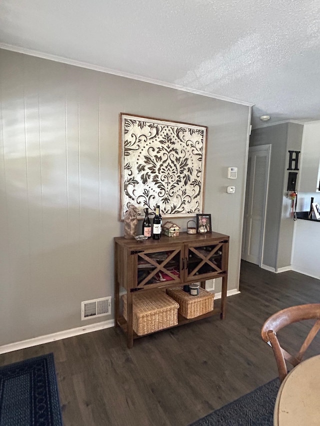 interior space with hardwood / wood-style floors, ornamental molding, and a textured ceiling