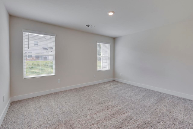 empty room with plenty of natural light and carpet