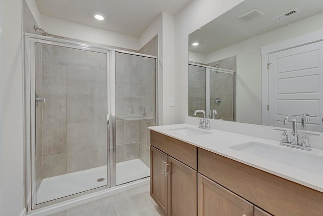 bathroom featuring tile patterned floors, a shower with shower door, and vanity