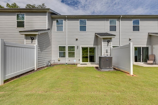 rear view of property with a lawn, a patio, and central AC