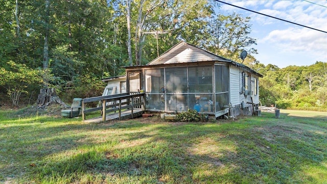 back of property with a sunroom and a lawn