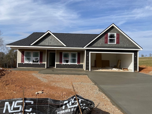 view of front facade with driveway, a shingled roof, a garage, and a porch