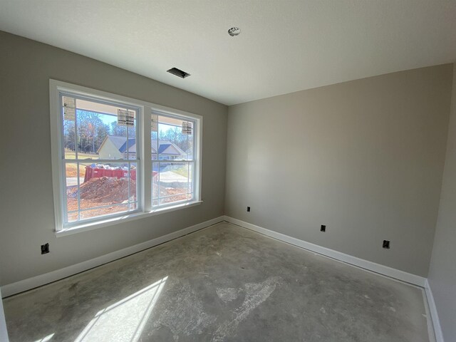 spare room with unfinished concrete floors and baseboards