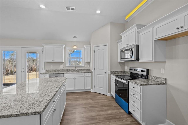 kitchen featuring white cabinets, visible vents, stainless steel appliances, and a sink