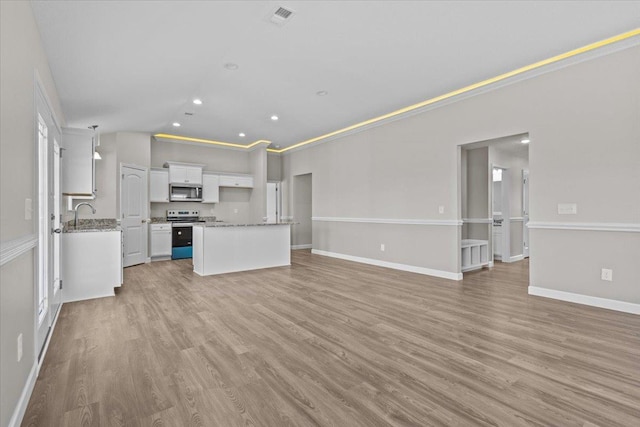 kitchen featuring light wood finished floors, visible vents, appliances with stainless steel finishes, open floor plan, and white cabinetry