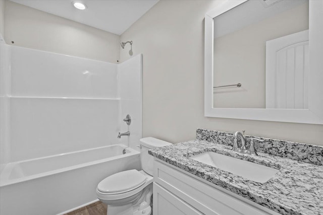 full bath with wood finished floors, shower / washtub combination, vanity, and toilet