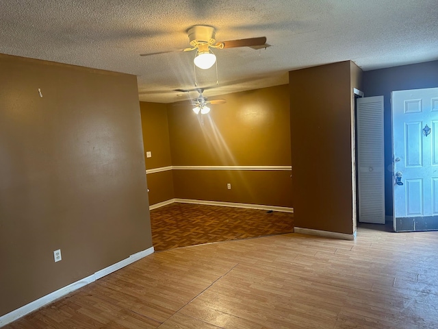 spare room with ceiling fan, light hardwood / wood-style floors, and a textured ceiling