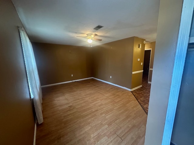 empty room with ceiling fan and light hardwood / wood-style flooring