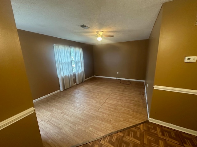 empty room with hardwood / wood-style floors, ceiling fan, and a textured ceiling