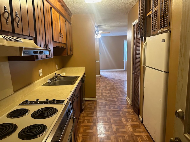 kitchen with a textured ceiling, ceiling fan, sink, and white appliances