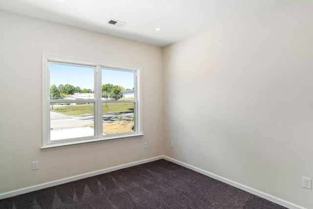 unfurnished room with dark colored carpet