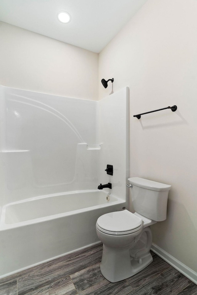 bathroom with wood-type flooring, toilet, and shower / bathing tub combination