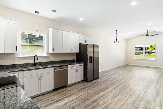 kitchen with light wood-type flooring, vaulted ceiling, sink, and appliances with stainless steel finishes