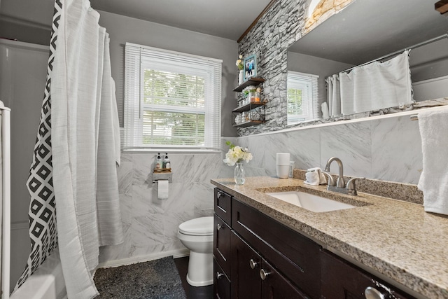 full bathroom featuring a wealth of natural light, vanity, toilet, and tile walls