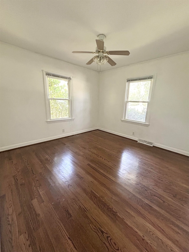 empty room featuring dark wood-type flooring and ceiling fan