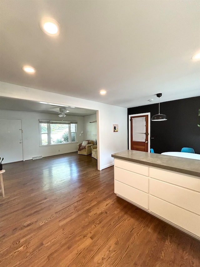 unfurnished living room with wood-type flooring and ceiling fan