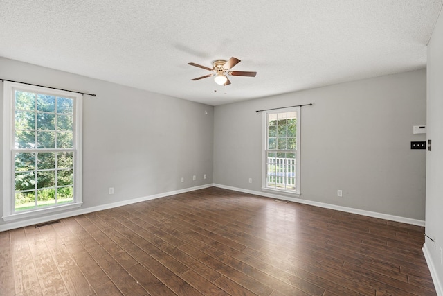 spare room featuring dark wood-type flooring, a textured ceiling, and ceiling fan