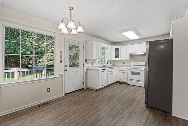 kitchen with ornamental molding, white appliances, a chandelier, dark hardwood / wood-style flooring, and sink