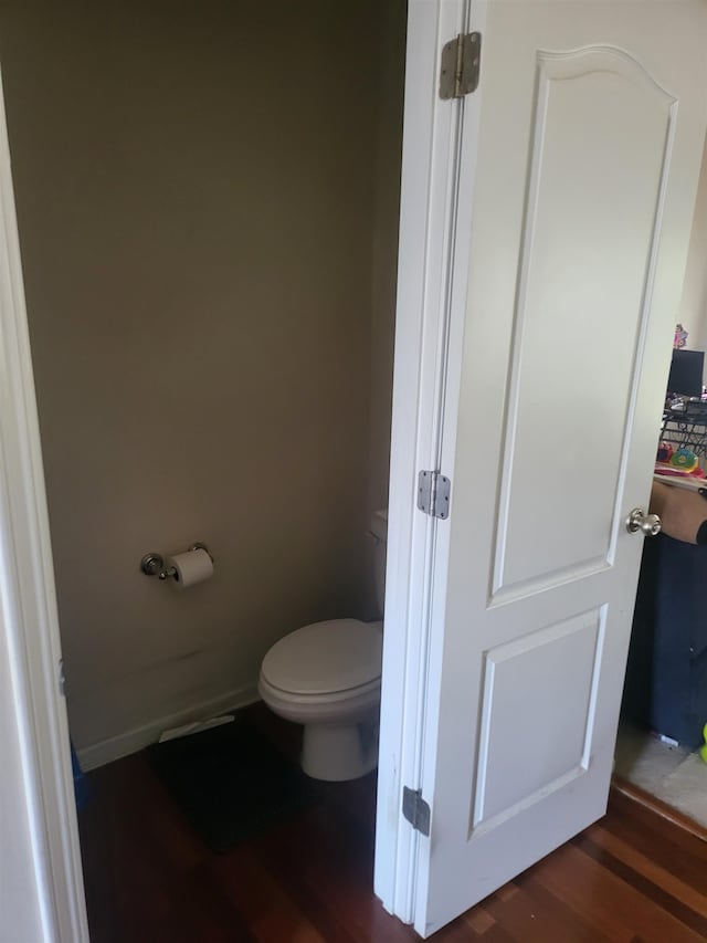 bathroom featuring wood-type flooring and toilet