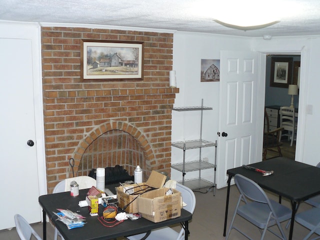 dining area with a textured ceiling and a brick fireplace