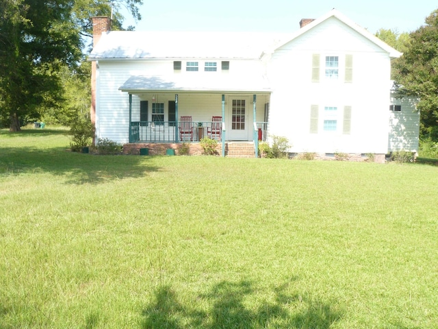 rear view of house featuring a porch and a yard