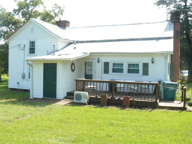 rear view of property featuring a yard and a deck