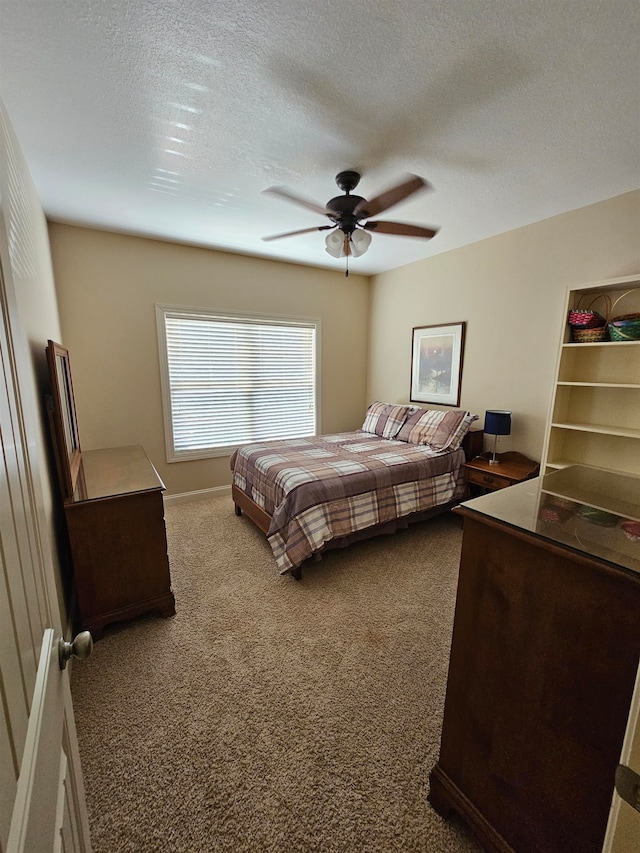 bedroom featuring ceiling fan, a textured ceiling, and carpet floors