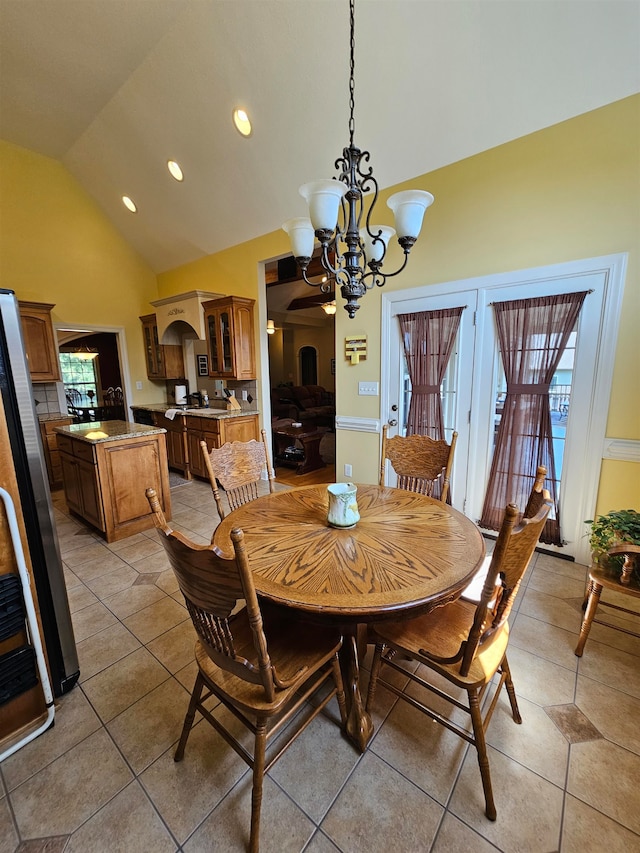 dining area featuring a notable chandelier, high vaulted ceiling, and light tile patterned flooring