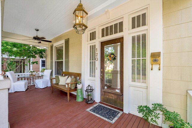 view of exterior entry featuring ceiling fan and covered porch