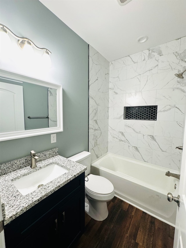 full bathroom featuring tiled shower / bath, vanity, toilet, and wood-type flooring