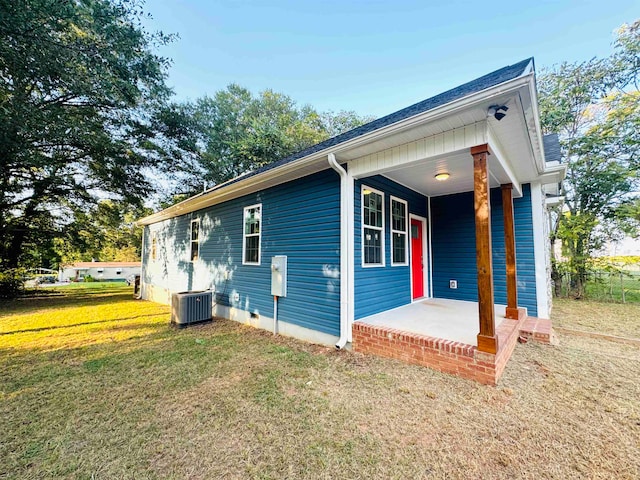 exterior space with a front yard, a porch, and central AC