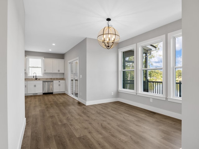 unfurnished living room with a chandelier, dark hardwood / wood-style flooring, and sink