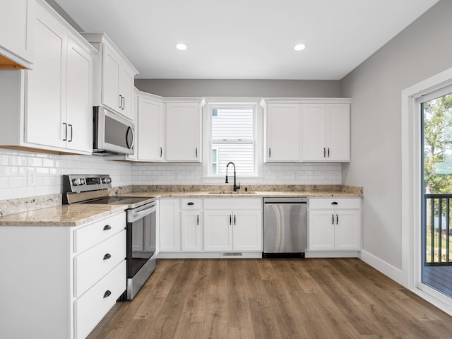 kitchen featuring white cabinets, hardwood / wood-style flooring, stainless steel appliances, and sink