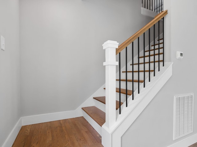 stairway with hardwood / wood-style floors