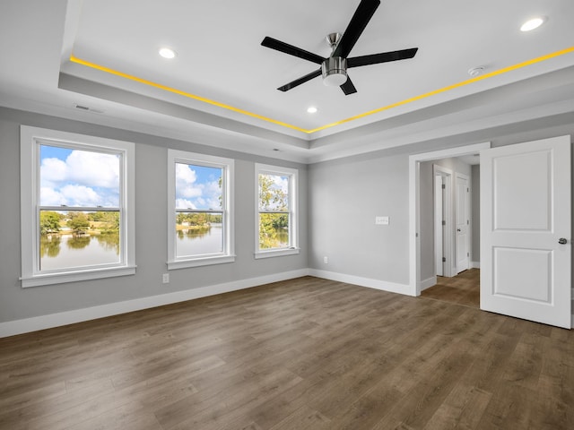 spare room featuring ceiling fan, dark hardwood / wood-style floors, and a raised ceiling