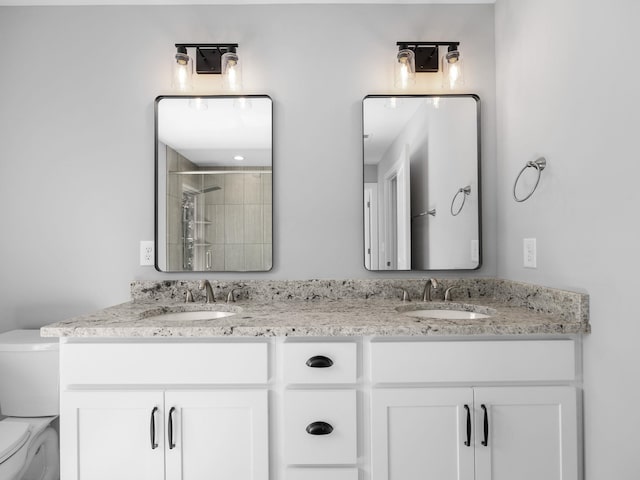 bathroom featuring vanity, toilet, and a shower with shower door