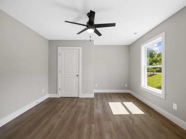 empty room with ceiling fan and dark hardwood / wood-style floors