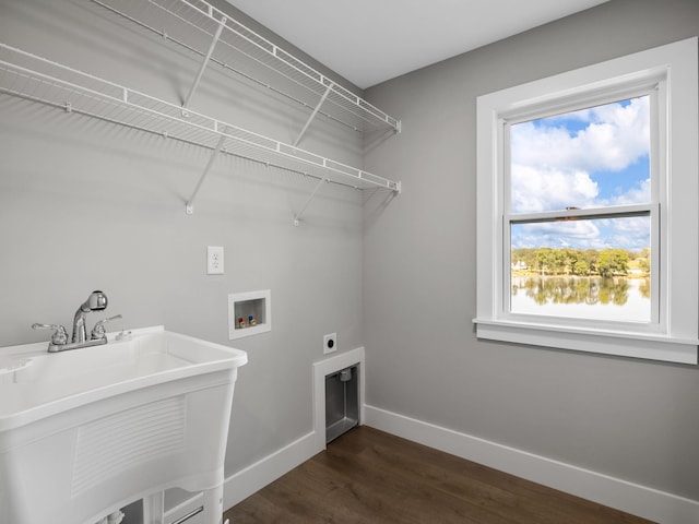 clothes washing area with dark wood-type flooring, hookup for a washing machine, electric dryer hookup, and sink