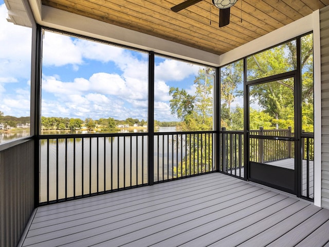 unfurnished sunroom featuring a healthy amount of sunlight, ceiling fan, and a water view