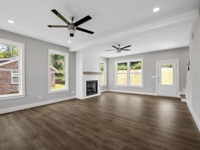 unfurnished living room featuring a large fireplace, ceiling fan, and dark wood-type flooring