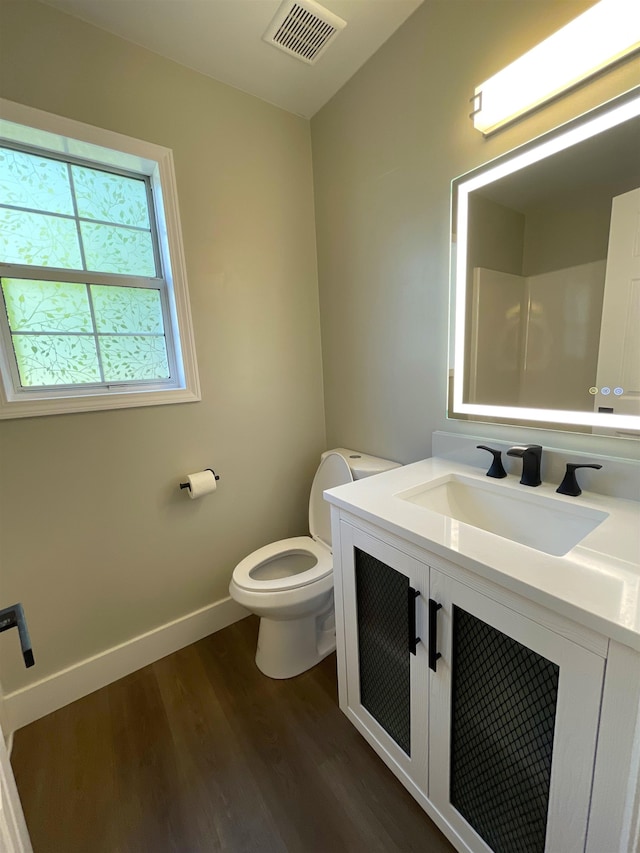 bathroom featuring vanity, toilet, and hardwood / wood-style flooring